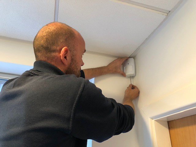 engineer servicing burglar alarm